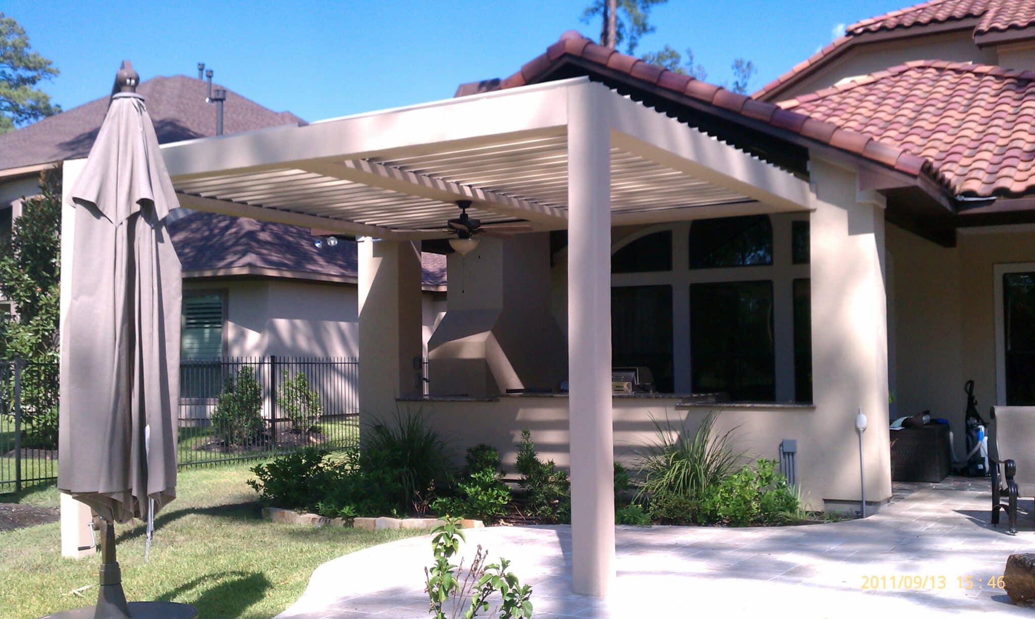 Louvered roof system covering outdoor hallway walkway with adjustable slats by 21st Century Sunrooms Houston TX