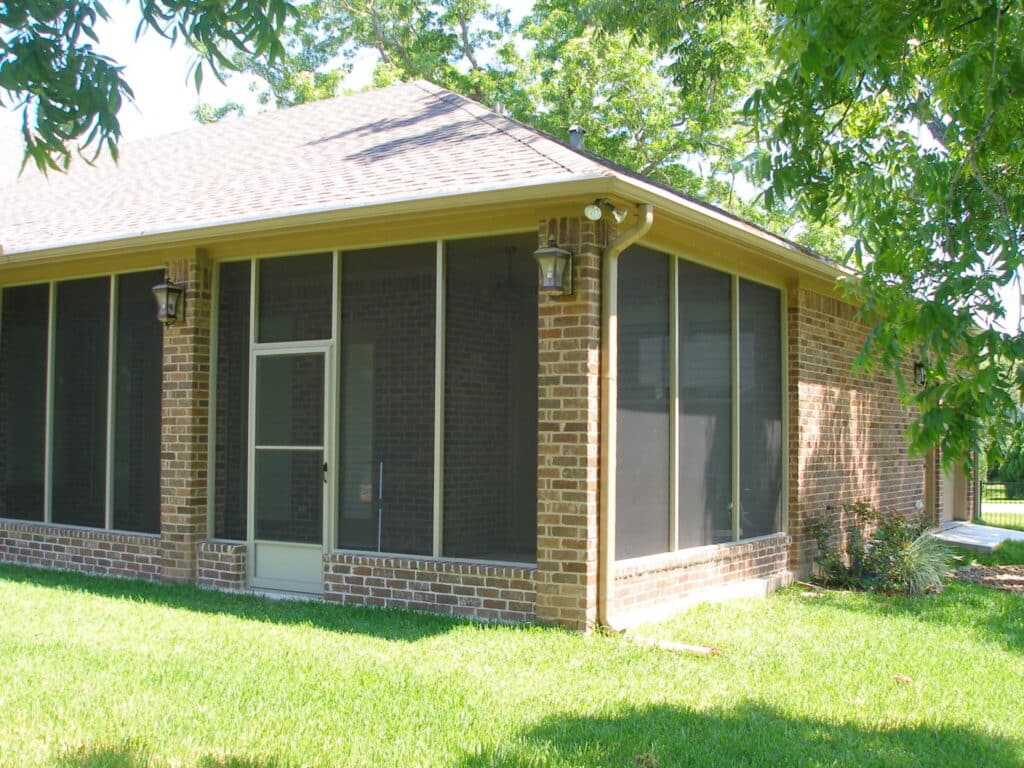 Happy homeowners enjoying their bug-free patio enclosure by 21st Century Sunrooms Houston TX